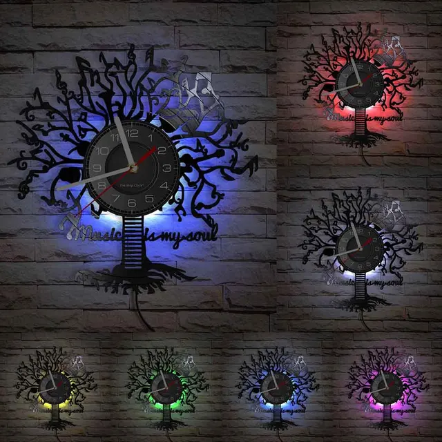 Music-inspired Tree Wall Clock, featuring a decorative tree frame and illuminated in seven different colored lights set against a brick wall background.